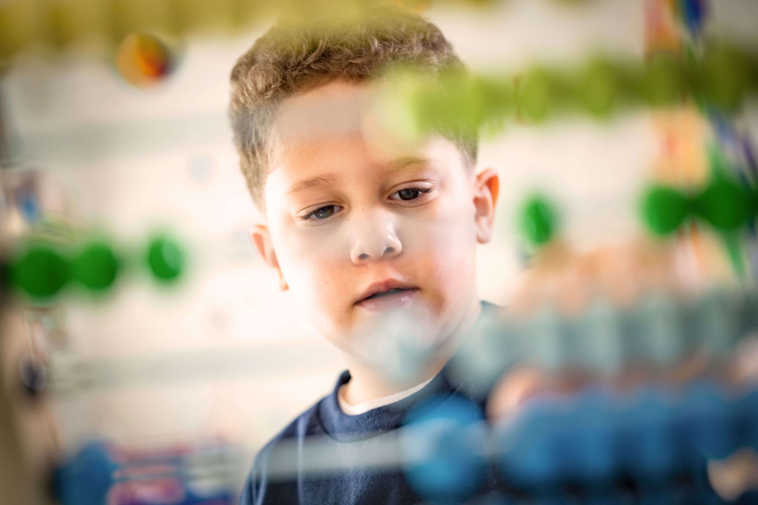 A young child concentrates on a hands-on classroom activity.